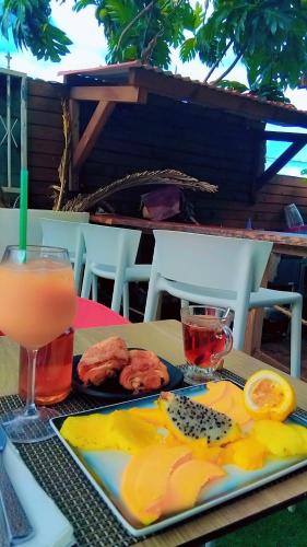 a plate of food on a table with a drink at Tidododesiles in Bouillante