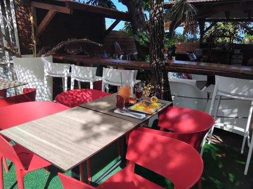 a table and red chairs at a restaurant at Tidododesiles in Bouillante