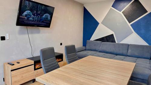 un salon avec un canapé, une table et une télévision dans l'établissement Charmant T1 - Chevigny-St-Sauveur, à Chevigny-Saint-Sauveur