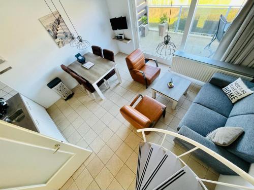 a living room with a blue couch and chairs at Schorrebloem 9* in Nieuwvliet