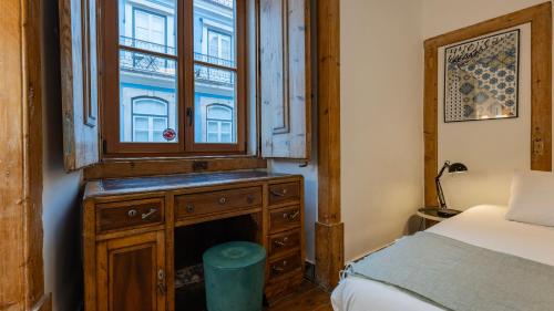 a bedroom with a bed and a window and a dresser at Portuguese Charm Guesthouse by LovelyStay in Lisbon