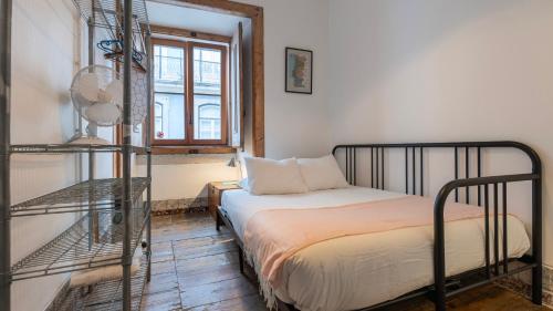 a small bedroom with a bed and a window at Portuguese Charm Guesthouse by LovelyStay in Lisbon