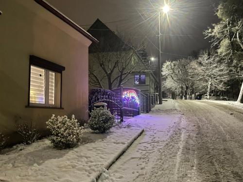 a snow covered street with a house and a street light at Fantazja Góra Św Anny in Góra Świętej Anny