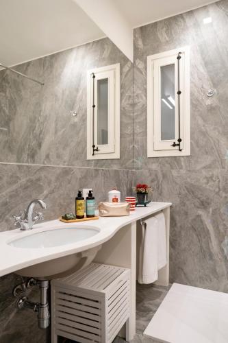 a bathroom with a sink and two mirrors at Palazzo Planeta in Palermo