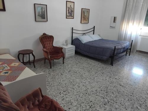 a bedroom with a bed and a chair at A casa di Adele in Caserta