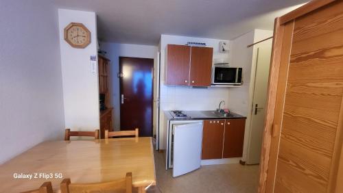 Il comprend une petite cuisine avec une table et une petite cuisine avec une table. dans l'établissement Le Charvin 211, à Manigod