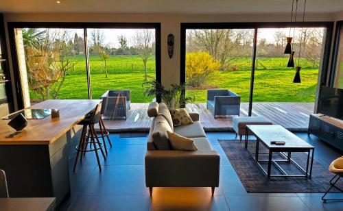 un salon avec un canapé et une table dans l'établissement Villa en bois à la campagne - 20 min de Rouen, à Morgny-la-Pommeraye