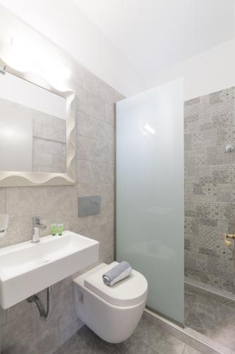 a bathroom with a sink and a toilet and a mirror at Studios Anais in Limenas