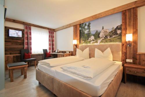 a bedroom with a large bed with a painting on the wall at Zeller Hof in Ruhpolding