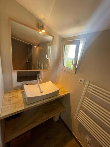 une salle de bain avec un lavabo blanc et un miroir dans l'établissement Charmante maison au coeur du village - 2 chambres, à Lambesc