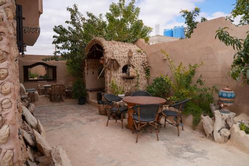 a patio with a table and chairs in a house at People to People Siwa in Siwa