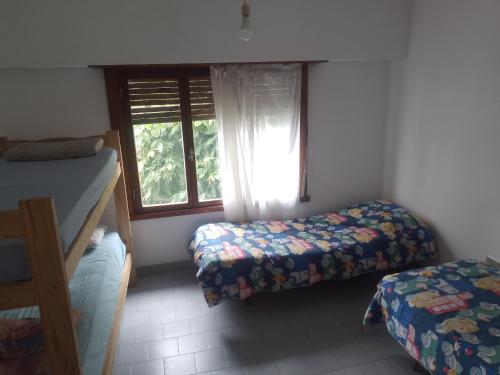 a bedroom with two beds and a window at Casa chalet neco in Necochea
