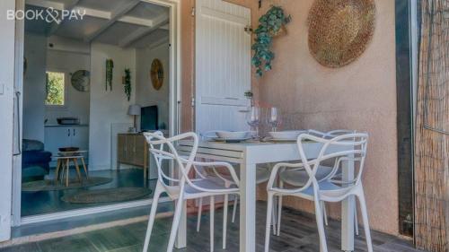 - une table à manger blanche avec 4 chaises blanches dans l'établissement Villa Club avec terrasse à 5 min à pied de la plage, à Sanary-sur-Mer
