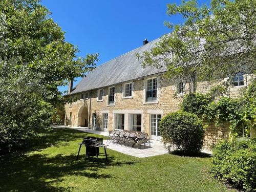 a large brick building with a picnic table in the yard at La Maison de Thérèse, Longère 15 people in Bonneuil-Matours