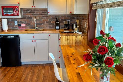 a kitchen with a counter with a vase of red roses at Sunset Studio in Tyee Beach