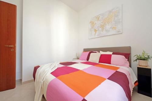 a bedroom with a bed with a colorful blanket at Centro storico - Ottimo Collegamento aeroportuale e Roma in Fiumicino