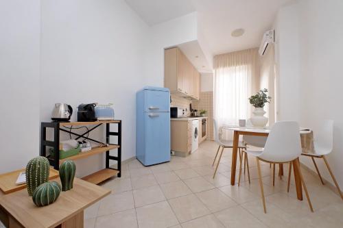 a kitchen with a blue refrigerator and a table at Centro storico - Ottimo Collegamento aeroportuale e Roma in Fiumicino