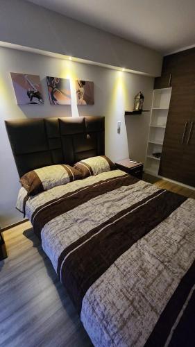 a bedroom with a large bed with a large headboard at SAMAY 122 - Acogedor Monoambiente muy cerca del centro! in Cochabamba