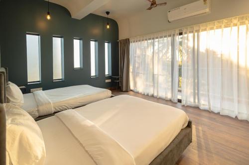 a bedroom with two beds and a large window at Quad Club - Resort and Spa, Nandi Hills in Nandigunda