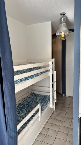 - une chambre avec des lits superposés blancs dans l'établissement L'échappé bleu, T2 vue imprenable sur la plage, à Andernos-les-Bains