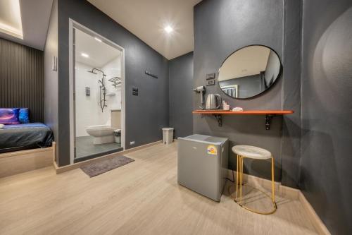 a bathroom with a sink and a mirror and a stool at Space Station Hostel in Ban Don Muang