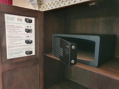 a microwave oven on a shelf next to a sign at Ostsee-Rittergut-Rügen mit BinzHotel & OrdensKapelle & RomantikGut in Binz