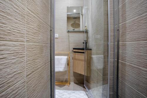 une salle de bain avec une douche avec une porte vitrée dans l'établissement Spacieux trois chambres proche GENEVE et ONU, à Ferney-Voltaire