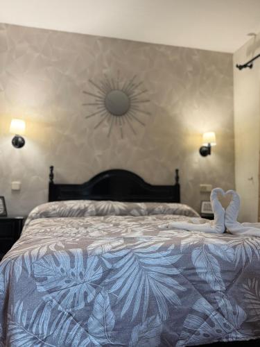 a bedroom with a large bed with a flower design on it at el valle hostal restaurante in La Pradera de Navalhorno