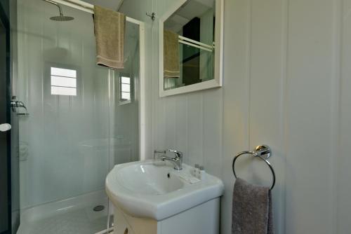 a white bathroom with a sink and a shower at SleepOver Komatipoort in Komatipoort
