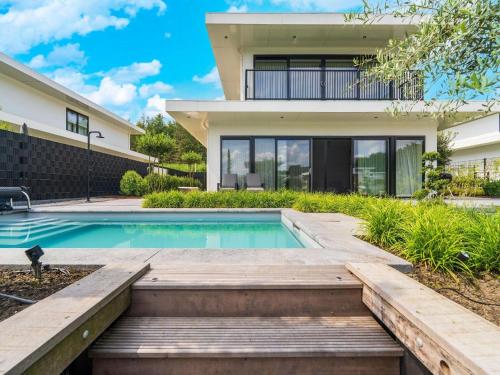 a home with a swimming pool and a house at Harderwold Villa Resort in Zeewolde
