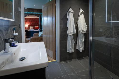 a bathroom with a sink and a shower and a mirror at The Artist's Garret in Broadwoodkelly