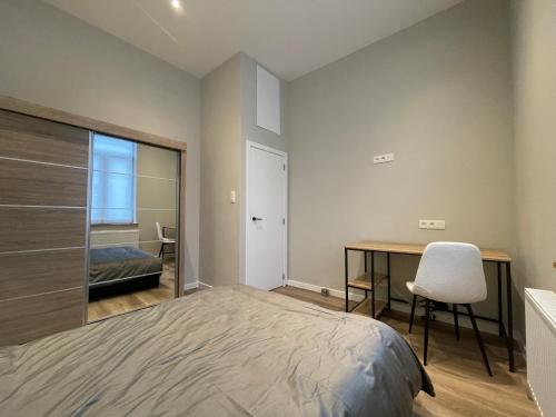una camera da letto con un letto e una scrivania con una sedia di Midi Station a Bruxelles