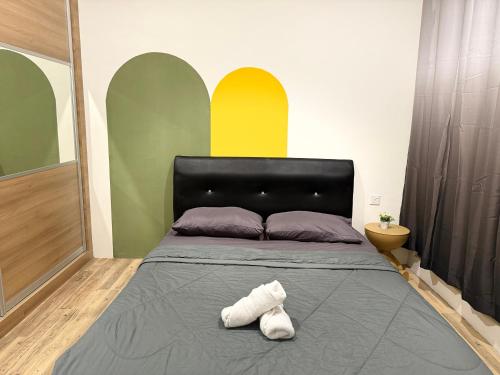 a bedroom with a bed with a black headboard at Gala City CornerApt Gala residence in Kuching