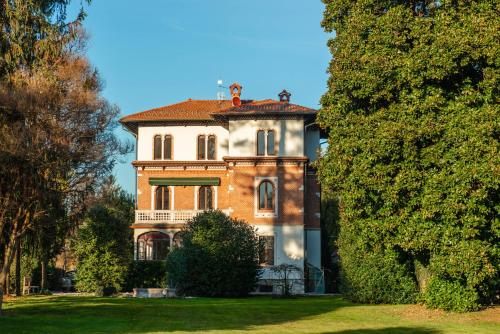 a large brick house in the middle of a yard at Villa Evelina in Travedona