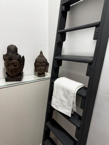 une étagère avec deux têtes et une serviette dans l'établissement Spacieux et lumineux duplex arty au centre de Sète, à Sète