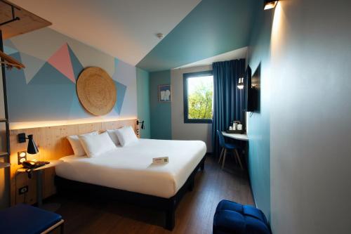 une chambre d'hôtel avec un lit et une table dans l'établissement ibis Styles Evry Lisses, Évry-Courcouronnes
