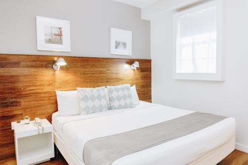 a bedroom with a white bed and a wooden wall at Riviere South Beach Hotel in Miami Beach