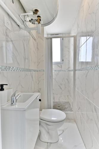 une salle de bain blanche avec toilettes et douche dans l'établissement Friendly and bright apartment - V, à Gagny
