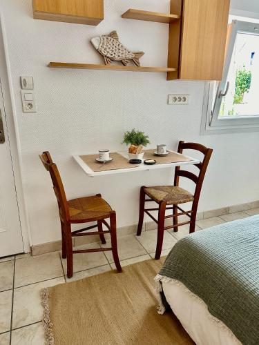 une pièce avec une table, des chaises et un lit dans l'établissement Jolie chambre à 2 mn à pied de la plage, à Loctudy