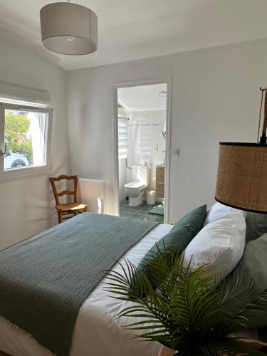 - une chambre avec un lit et une plante dans l'établissement Jolie chambre à 2 mn à pied de la plage, à Loctudy