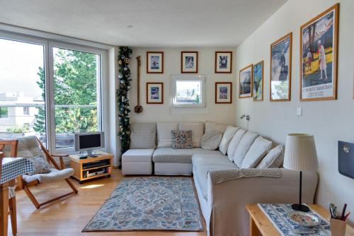 a living room with a couch and a tv at Chesa Quadratscha - Samedan in Samedan