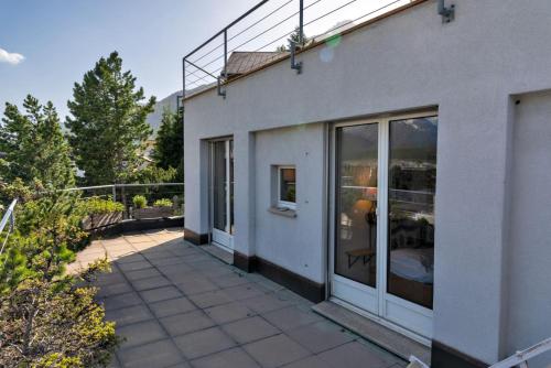 a house with a patio and a balcony at Chesa Quadratscha - Samedan in Samedan