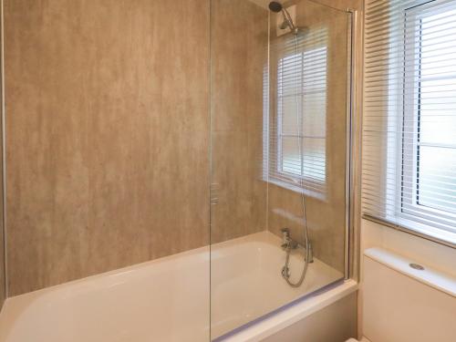 a bathroom with a shower with a tub at Squirrels Snug in Windermere
