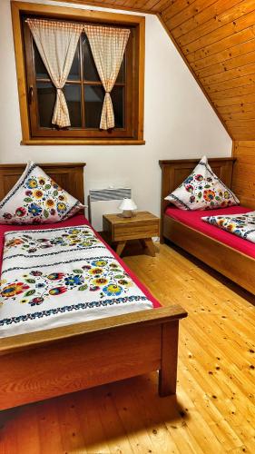 a bedroom with two beds and a window at Drevenička Amálka in Liptovský Trnovec
