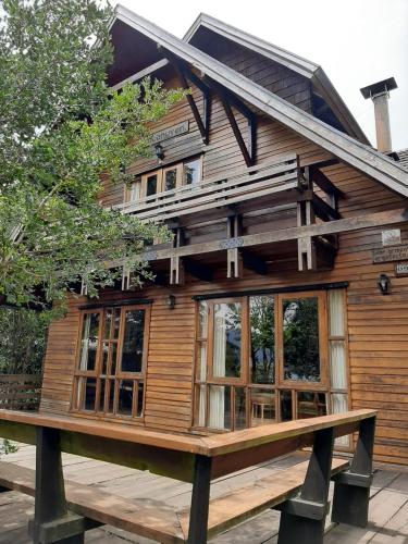 une maison en bois avec des fenêtres sur une plateforme en bois dans l'établissement Casa orilla de playa pucón, à Pucón