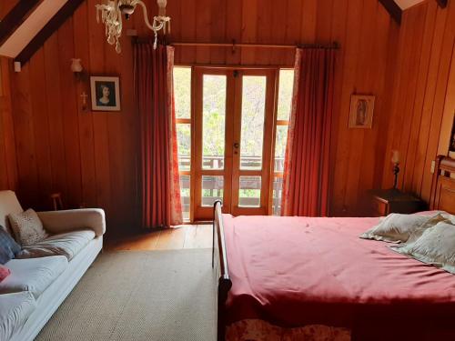 a bedroom with a bed and a couch in it at Casa orilla de playa pucón in Pucón