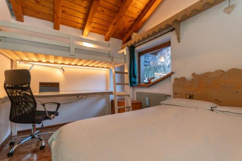 a bedroom with a bed and a desk and a chair at Chalet Kalipe in Rocca Pietore