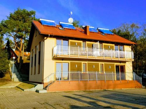 a house with solar panels on top of it at Eko-pokoje w Krynicy Morskiej-Piaski w ośrodku kolonijnym in Nowa Karczma