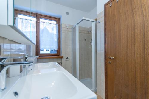 a bathroom with a tub and a shower and a sink at Chalet Kalipe in Rocca Pietore