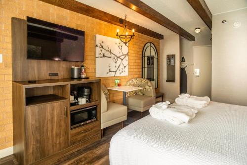 a bedroom with a bed and a flat screen tv at Old Orchard Inn in Wolfville